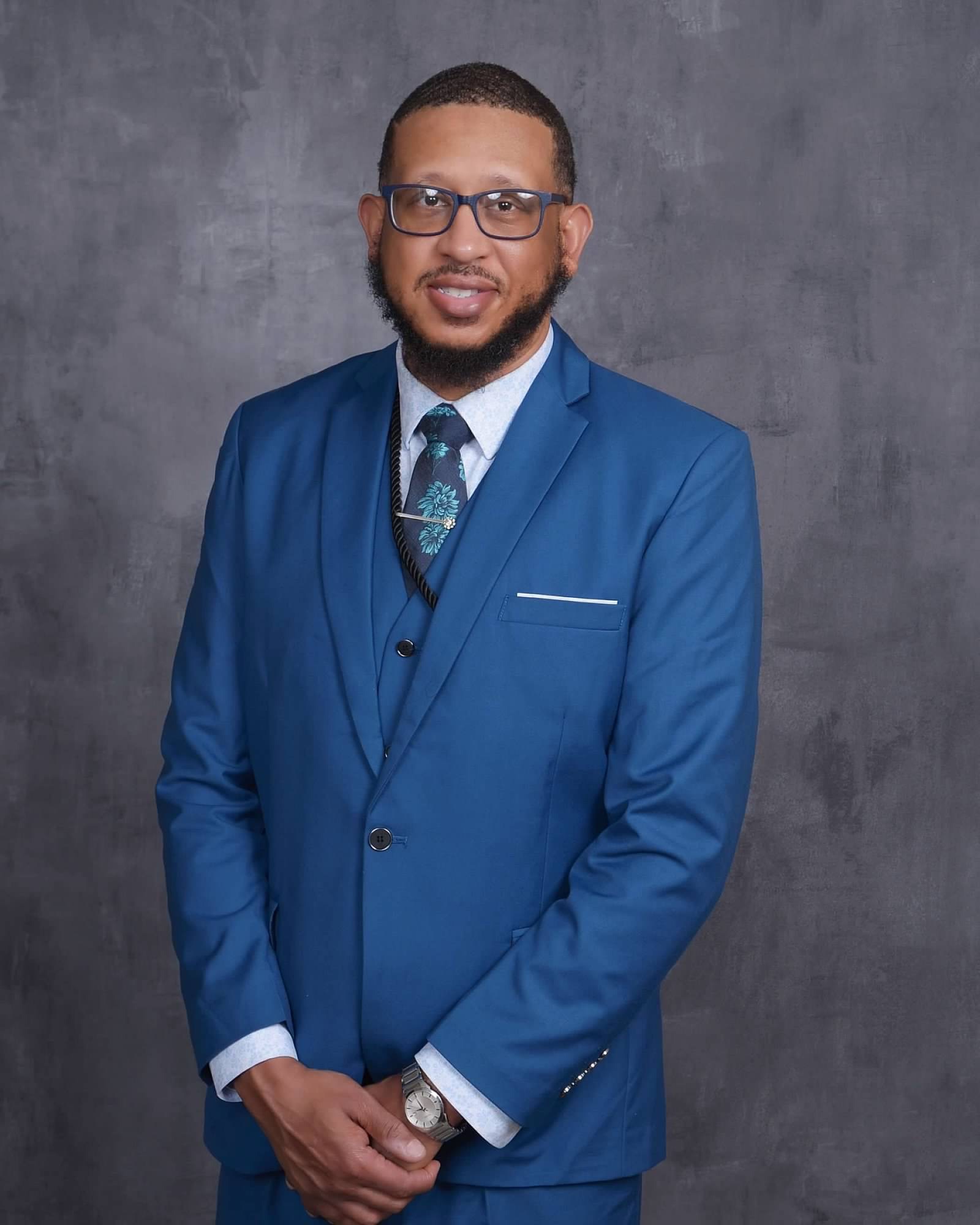 Portrait of Wayne D. Comer II in a blue three-piece suit